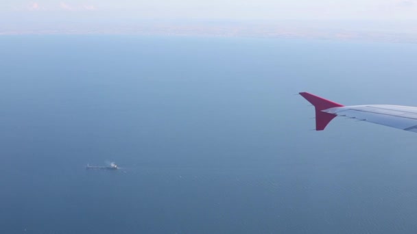Крыло самолета и синее море — стоковое видео