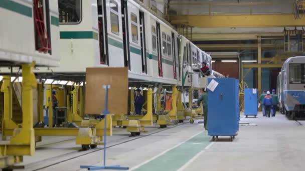 Trabajadores montan trenes en taller en fábrica — Vídeo de stock