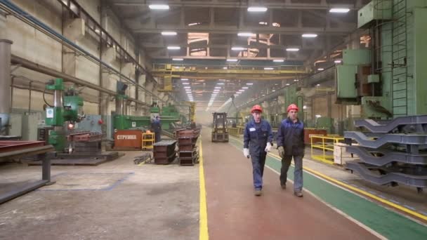 Werknemers lopen en lader rijdt op workshop — Stockvideo