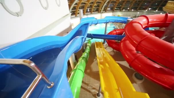 Färgglada vattenrutschbanor på indoor waterpark — Stockvideo