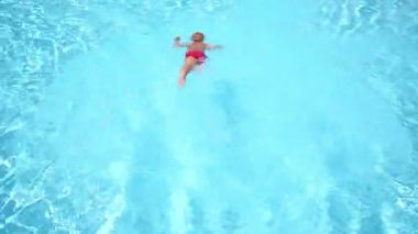 Küçük çocuk mavi havuzda atlar