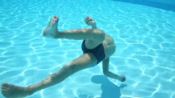 Teen boy under water in pool — Stock Video