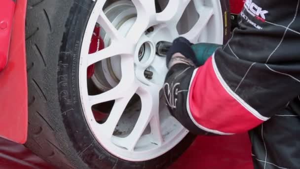 Mecánico del automóvil desenrosca la rueda del coche — Vídeos de Stock