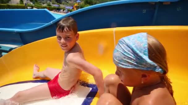 Menino desliza na corrediça de água em aquapark — Vídeo de Stock