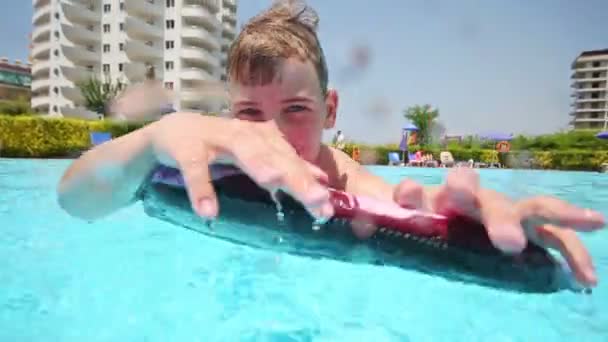 Niño se baña en la piscina en skimboard — Vídeo de stock