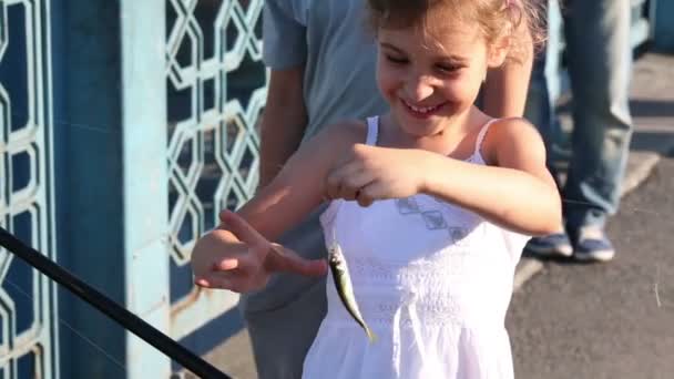 Gelukkig meisje speelt met kleine vissen — Stockvideo