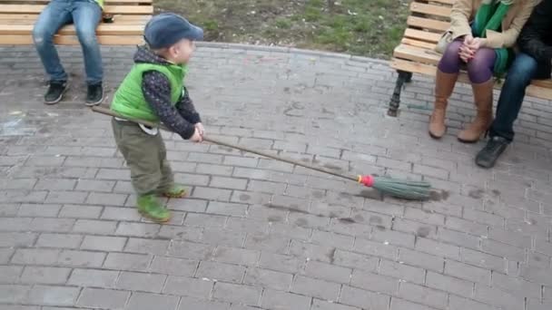 Pequeño niño juega con escoba — Vídeo de stock