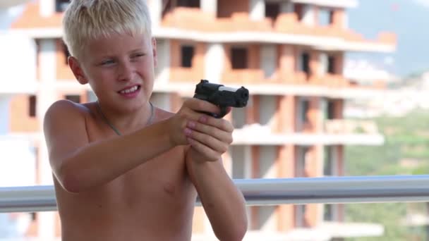 Boy covering eye aiming with pistol — Stock Video