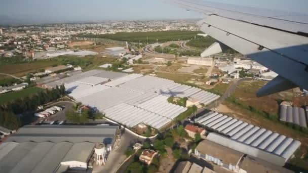 Latający samolot z widokiem na dach hangarów — Wideo stockowe