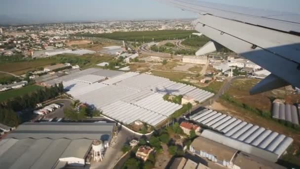 Flying plane with view of roof hangars — Stock Video