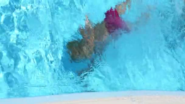 Kleine jongen duiken in zwembad — Stockvideo