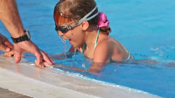 Niña aprendiendo a nadar en la piscina — Vídeo de stock