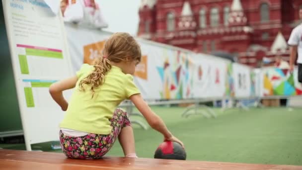 Niña captura pelota de peluche — Vídeo de stock