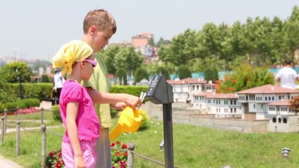 Niño y niña escuchando guía electrónico — Vídeo de stock