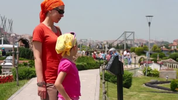 Vrouw en meisje luisteren elektronische gids — Stockvideo