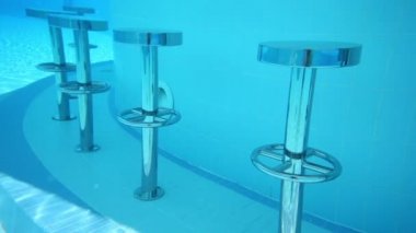 Su altında yuvarlak metal bar sandalyeler