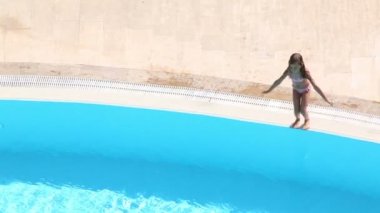Küçük kız havuz içine atlar