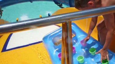 Çocuk su slayt üzerinde eğleniyor