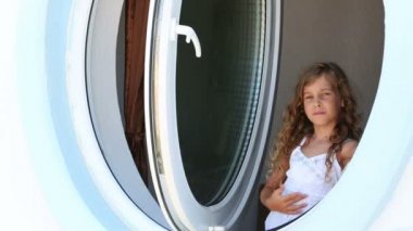 Beyaz elbiseli küçük kız gülümsüyor.