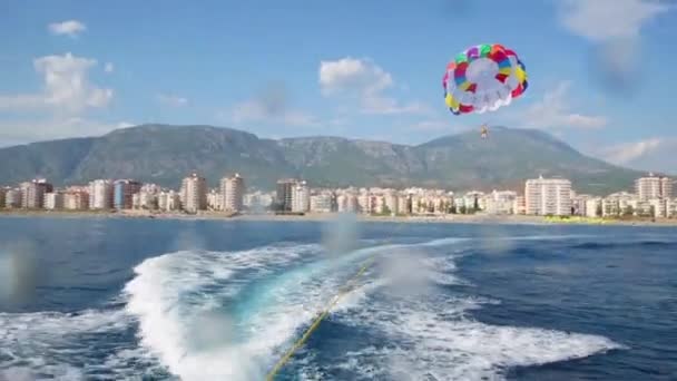 Seascape with coastline and parachute roped boat — Stock Video