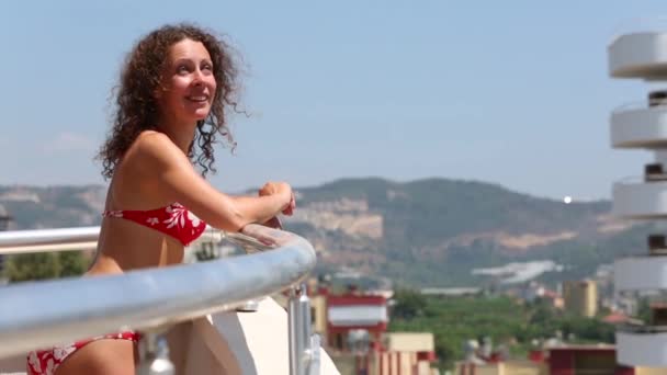 Mulher bonita feliz fica na varanda — Vídeo de Stock