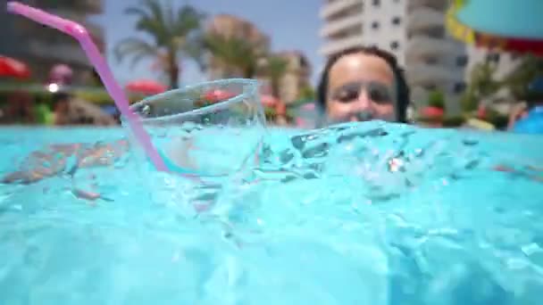 Woman swims to floating glass with soda — Stock Video