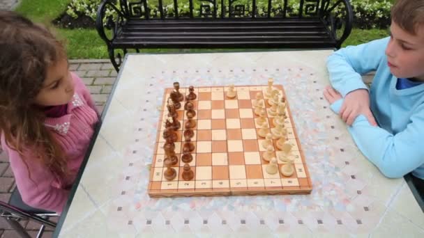 Garçon et fille jouer aux échecs dans le parc — Video