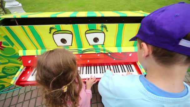 Мальчик и девочка играют на пианино — стоковое видео