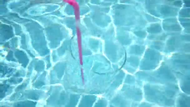 Vidrio con soda de paja flota en la piscina — Vídeos de Stock