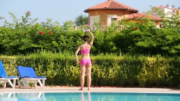 Молодая женщина делает упражнения с гантелями — стоковое видео