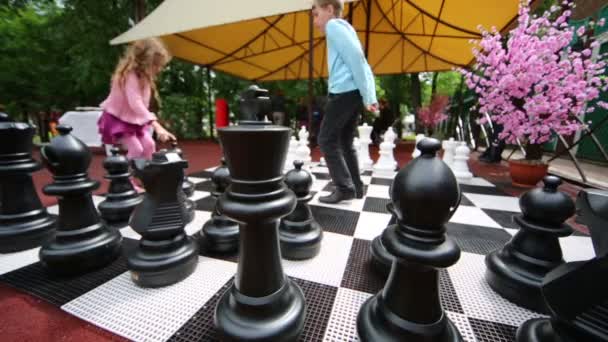 Boy teaching girl to play chess — Stock Video