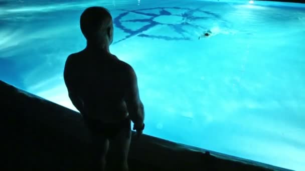 Homme adulte regarde garçon dans la piscine — Video