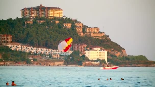 Menschen nehmen Parasail-Attraktion am Strand — Stockvideo