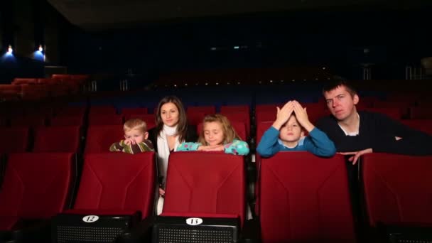 Vrouw en man met kinderen kijken naar film — Stockvideo