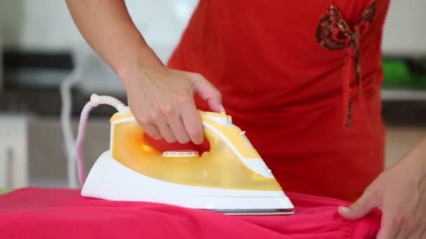 Housewife in red dress ironing laundry — Stock Video