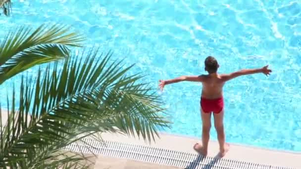 Boy takes sunbathe on edge of pool — Stock Video