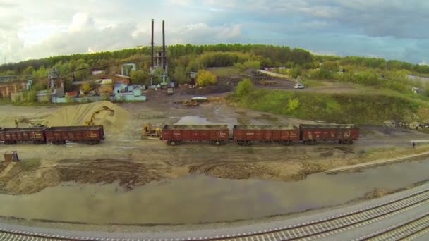 Excavator unloads gravel from cargo wagon — Stock Video