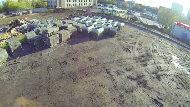 Palettes de matériaux de construction sur le terrain près du bus — Video
