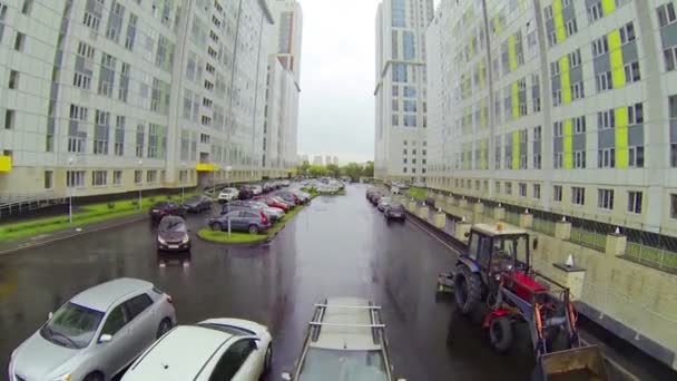 Много машин припарковано между зданиями — стоковое видео