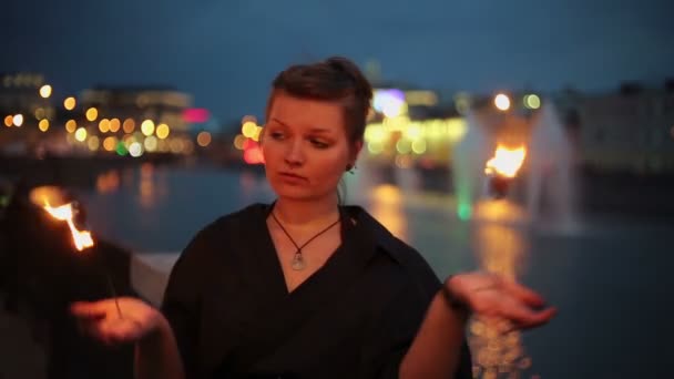Девушка в платье играет с огнем — стоковое видео