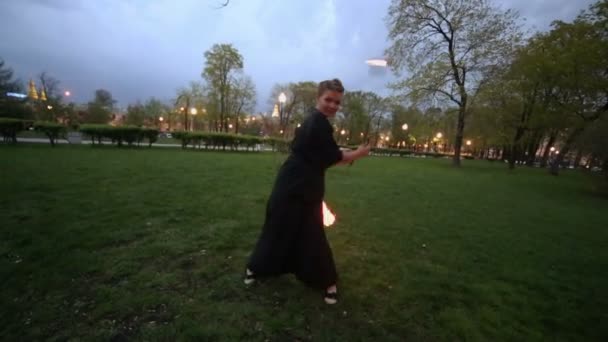 Frau in Schwarz dreht Poi mit Flamme — Stockvideo