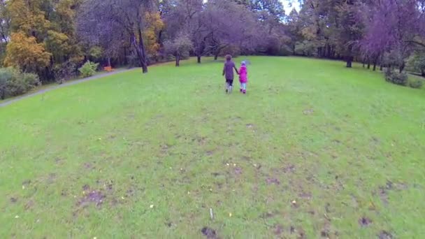 Mujer joven y su hija corriendo en el parque — Vídeo de stock