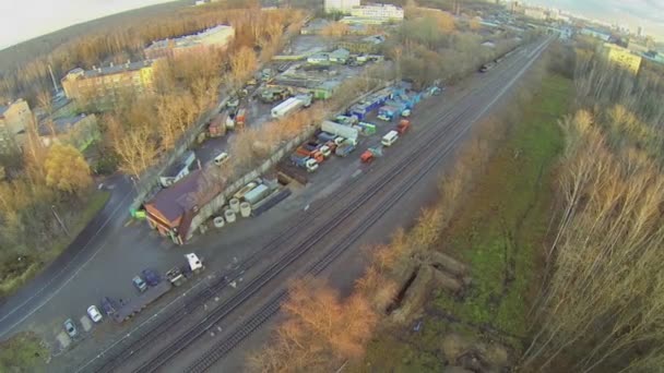 Verkehr auf regennasser Straße nahe Bahngleisen — Stockvideo