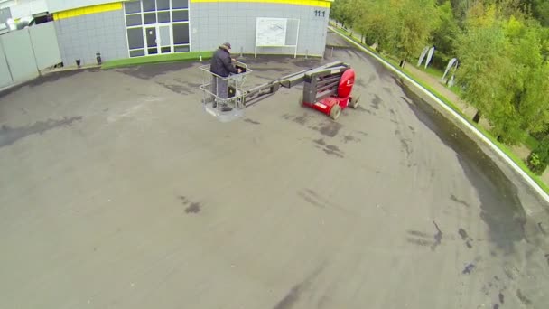 Worker maneuvering lift truck in courtyard — Stock Video