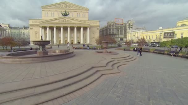 Dívka chodí na náměstí nedaleko budovy velké divadlo — Stock video