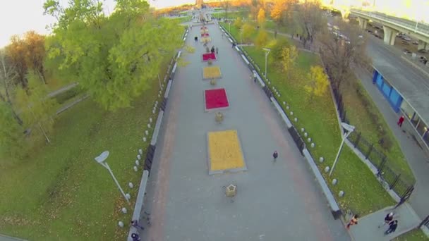 Громадяни ходять по алеї в парку — стокове відео