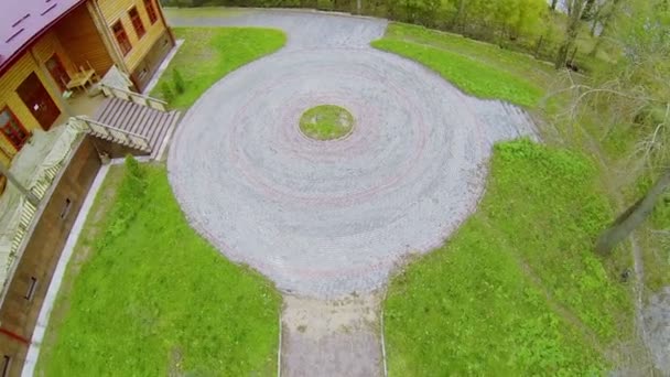 Pavimento redondo en el patio cerca de la casa de madera en el día de otoño — Vídeo de stock