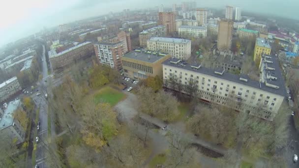 Stadsbild med trafik på våta gatorna nära boningshus — Stockvideo