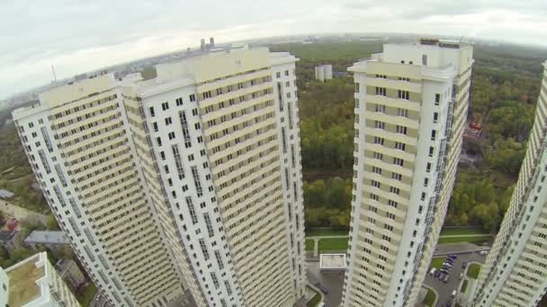 Вершина строительного комплекса с большим городом вдали, вид с воздуха — стоковое видео