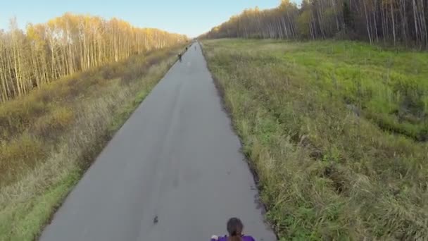 Peopel en bicicleta por carretera en el parque — Vídeos de Stock